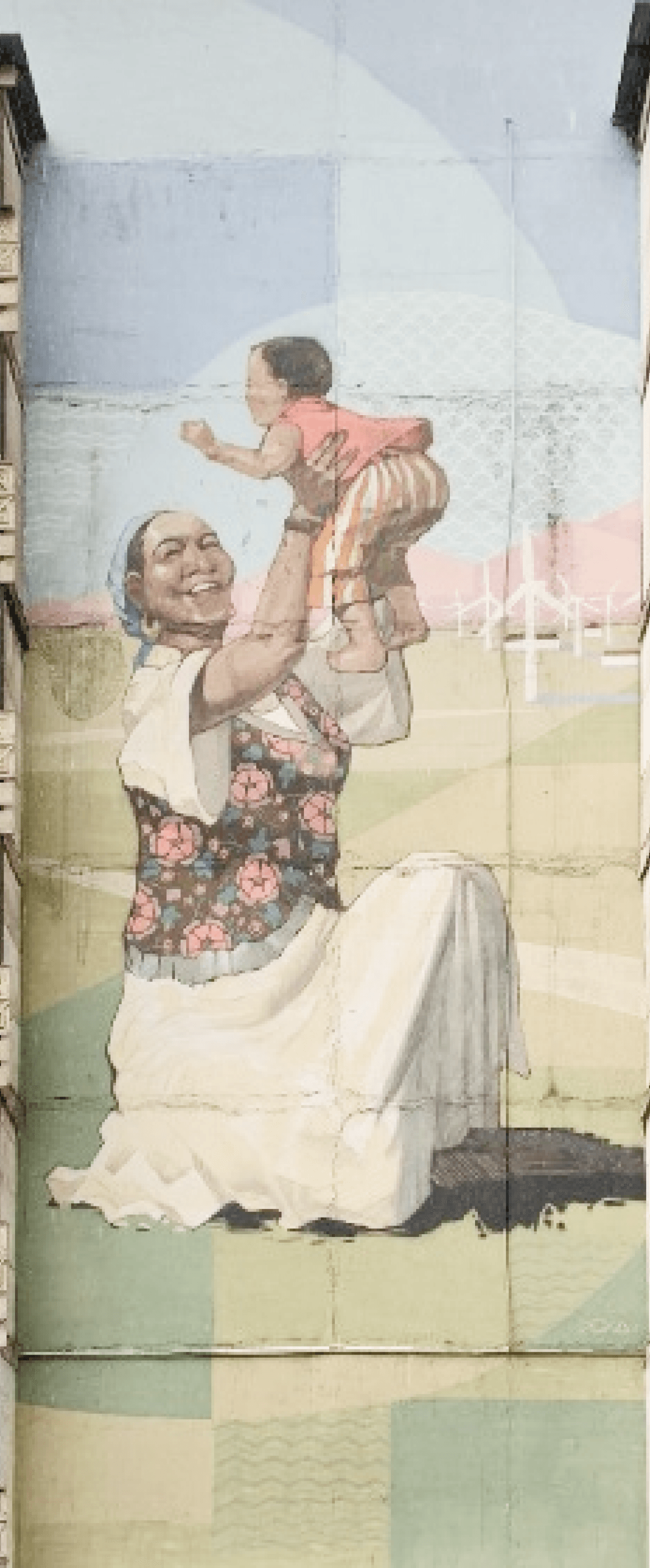 A photo of a mural on old soviet building in Kazakhstan depicting a mother holding a child up in the air.